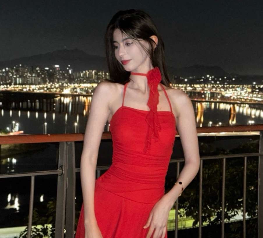 Maram in a red halter dress against the Seoul night skyline