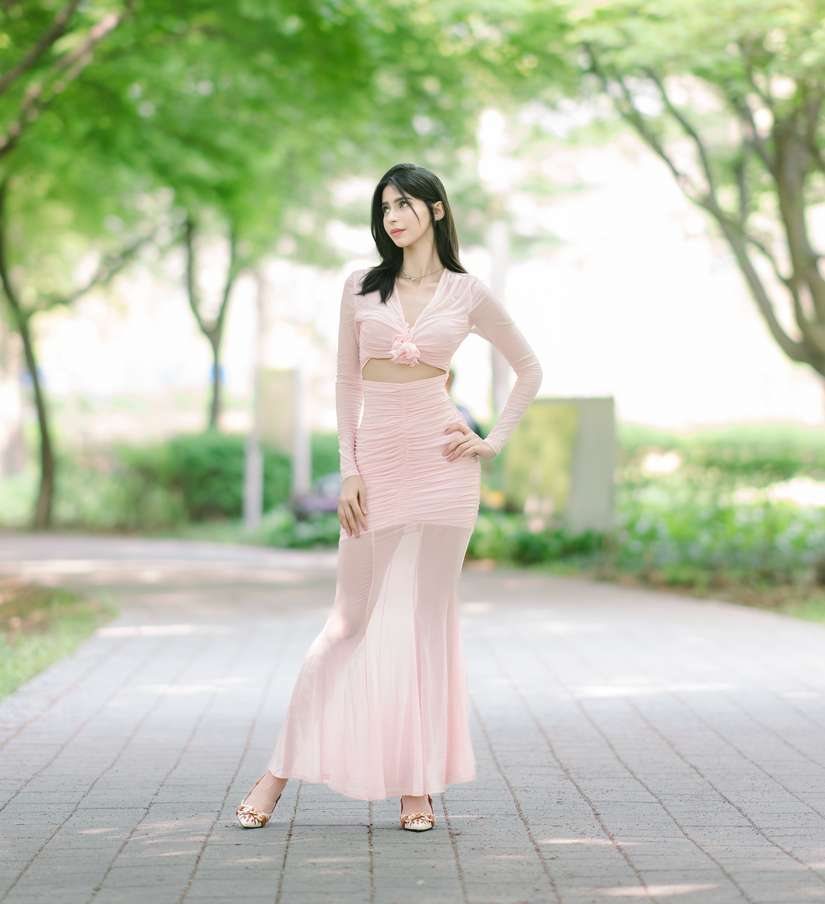 Maram in a pale pink mesh set standing on a park path