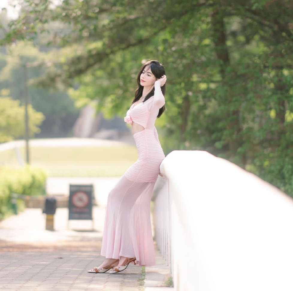 Maram in pink leaning on a white railing