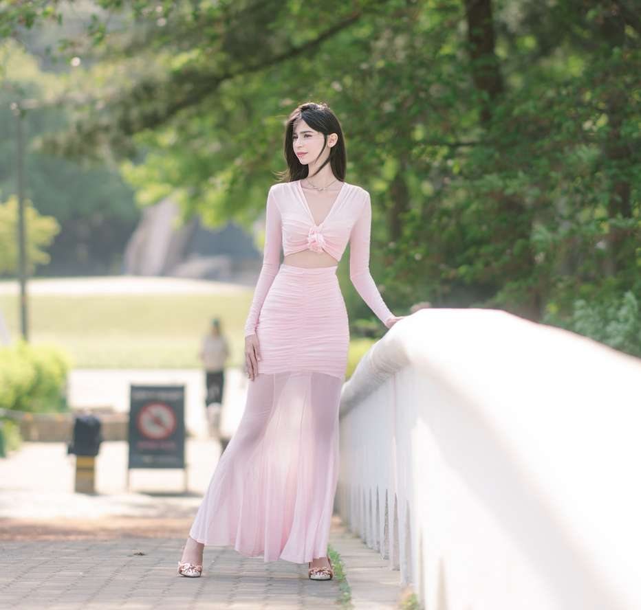 Maram in pink standing beside a white railing