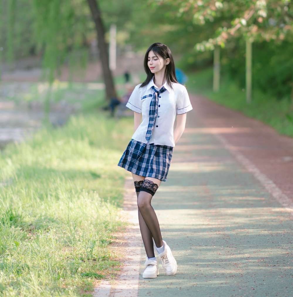Maram in a school-style uniform on a tree-lined path