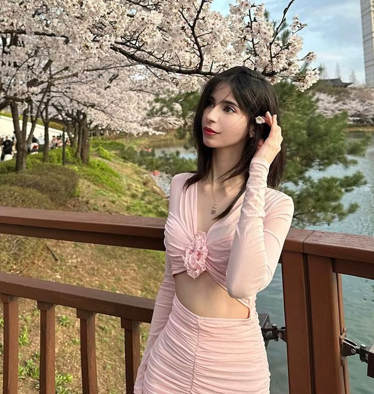 Maram in pink by a lake with cherry blossoms